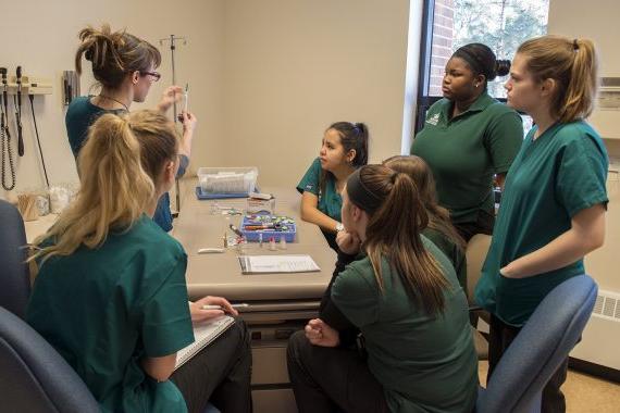 BSU护理专业的学生在实验室里围着桌子聊天
